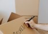 Moving House: Some Simple Ways To Make It Easier Moving House / Photo credit: https://www.pexels.com/photo/crop-man-writing-on-carton-box-word-kitchen-4506265/