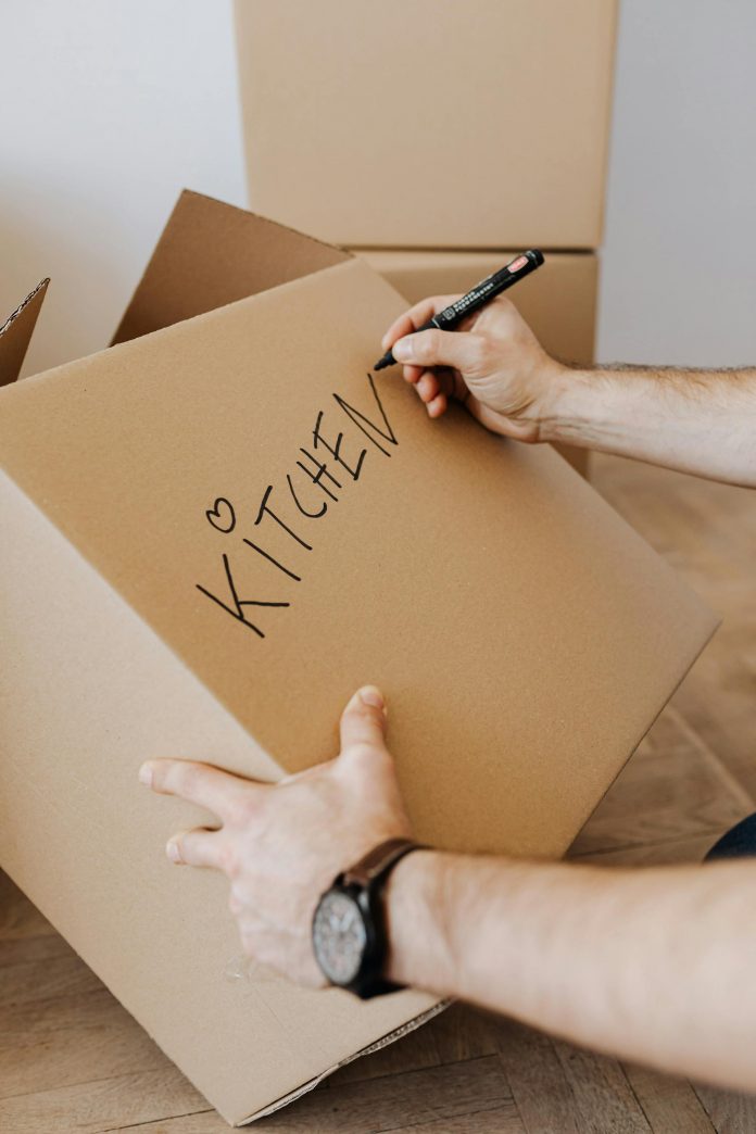 Moving House / Photo credit: https://www.pexels.com/photo/crop-man-writing-on-carton-box-word-kitchen-4506265/